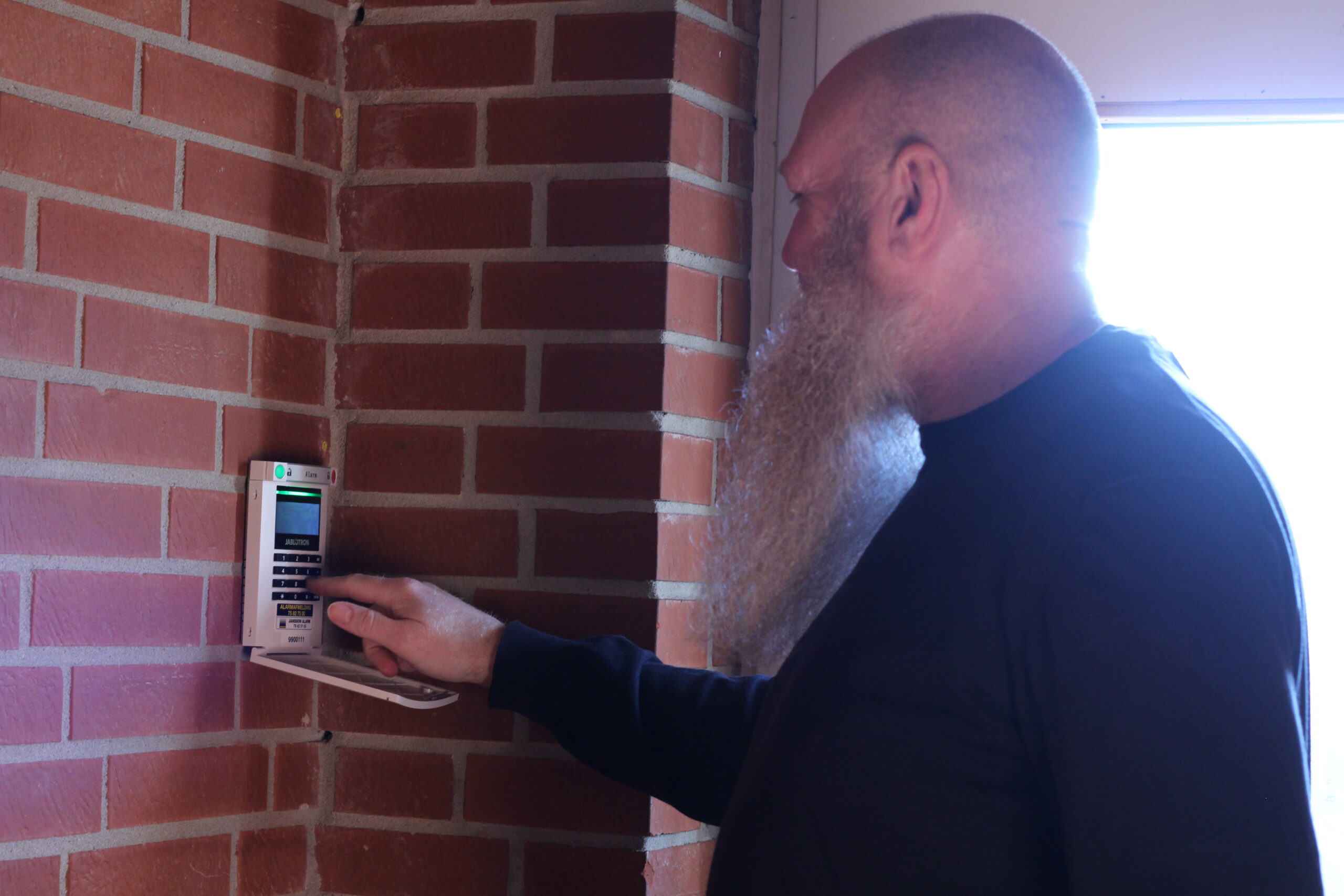 Adm. direktør Christian Schollert trykker på tyverialarm fra Jansson Alarm